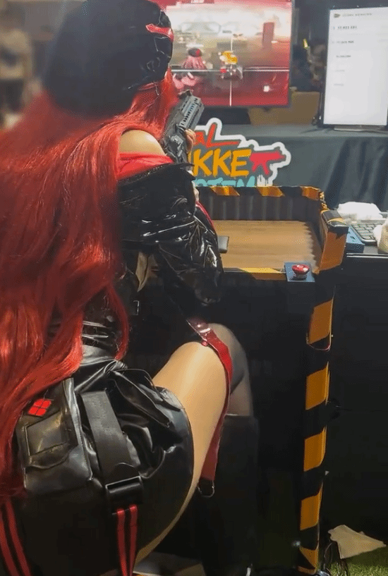 红发女Coser展会体验《NIKKE》射击游戏